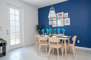 A dining area with a blue accent wall, white ceiling, and a white door. - Gorgeous 3Bd Close To Disney @ Festival Resort 661 (Davenport)