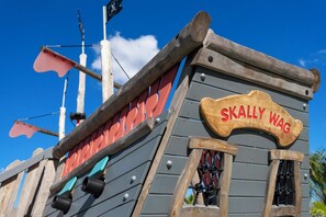 A wooden pirate ship-themed building with a sign reading "SKALLY WAG". - Gorgeous 4Bd W/ Pool & Waterpark @ Storey Lake 4836M (Kissimmee)