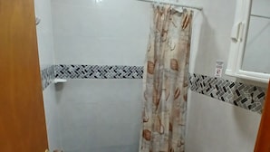 Une petite salle de bain avec une douche, des toilettes et un lavabo.