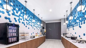 A modern kitchen with a central island, a refrigerator, and a microwave. - La Quinta by Wyndham Chelsea Birmingham (Chelsea)