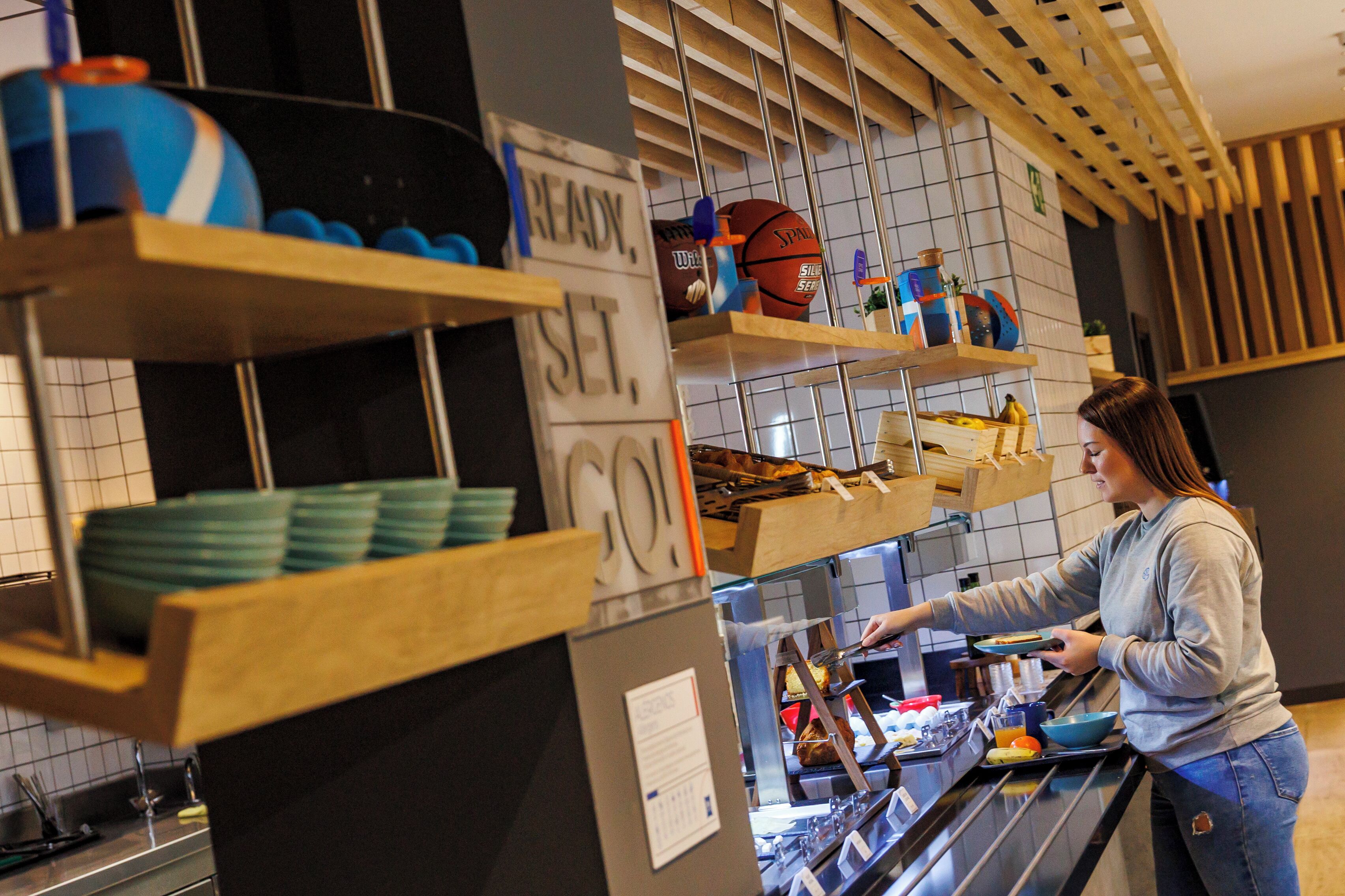 A breakfast bar with shelves holding plates, bowls, and a basketball.