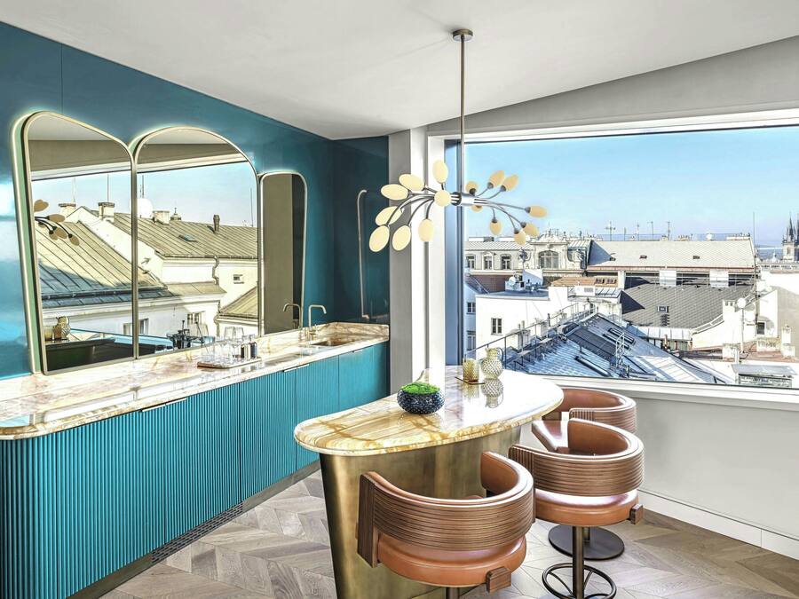A modern kitchen with a large window, a bar area, and a view of the cityscape.