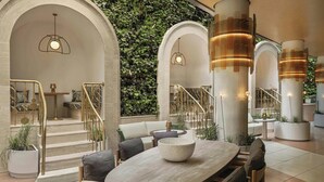 A modern interior with a staircase, seating area, and decorative columns. - W Prague (Prague)