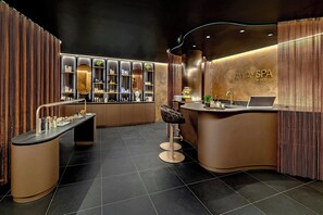 A modern spa reception area with a curved counter, a laptop, and a reception desk.