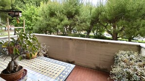 A balcony with a tiled floor, potted plants, and a view of trees. - SE092 - Senigallia, large four-room apartment with terrace (Senigallia)