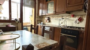 A kitchen with wooden cabinets, a stove, and a tiled backsplash. - SE092 - Senigallia, large four-room apartment with terrace (Senigallia)