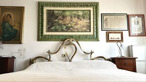 A bedroom with a bed, a framed painting, and a certificate on the wall. - SE092 - Senigallia, large four-room apartment with terrace (Senigallia)