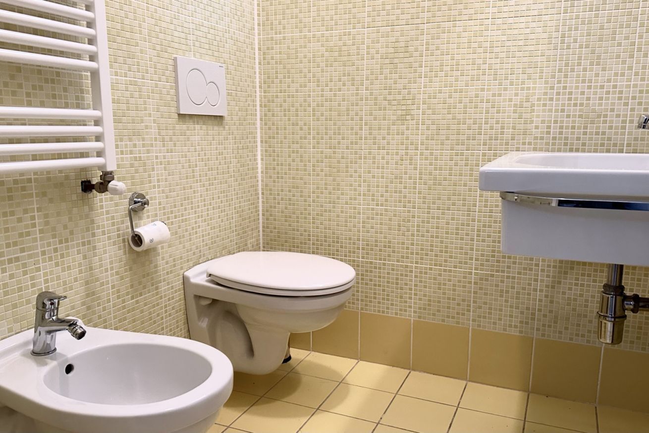 A bathroom with a toilet, bidet, and sink.