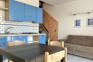 A kitchen with blue cabinets, a dining table, and chairs.