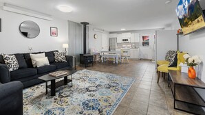 A modern living room with a black sofa, a coffee table, and a patterned rug. - Harmony Guest Home  (Flagstaff)
