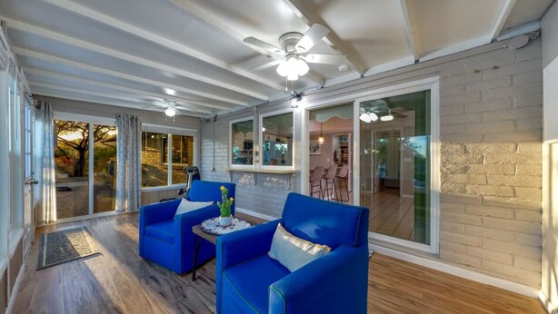 A spacious room with a ceiling fan, large windows, and a wooden floor. - Heated Pool & Hot Tub / 3 BR 2 BA / Big 360º Views (Tucson)