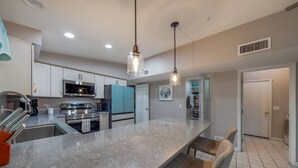 A modern kitchen with granite countertops, stainless steel appliances, and pendant lighting. - Heated Pool & Hot Tub / 3 BR 2 BA / Big 360º Views (Tucson)
