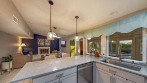 A modern kitchen with a large island, pendant lighting, and a view of the outdoors. - Heated Pool & Hot Tub / 3 BR 2 BA / Big 360º Views (Tucson)
