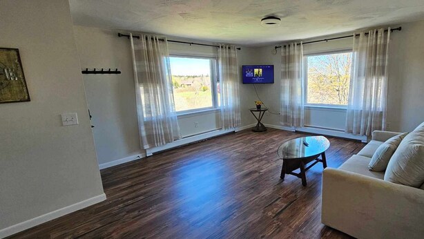 A living room with a sofa, a coffee table, and a TV on a stand. - New listing! Perfectly centered in the Birch Harbor village!

 (Gouldsboro)