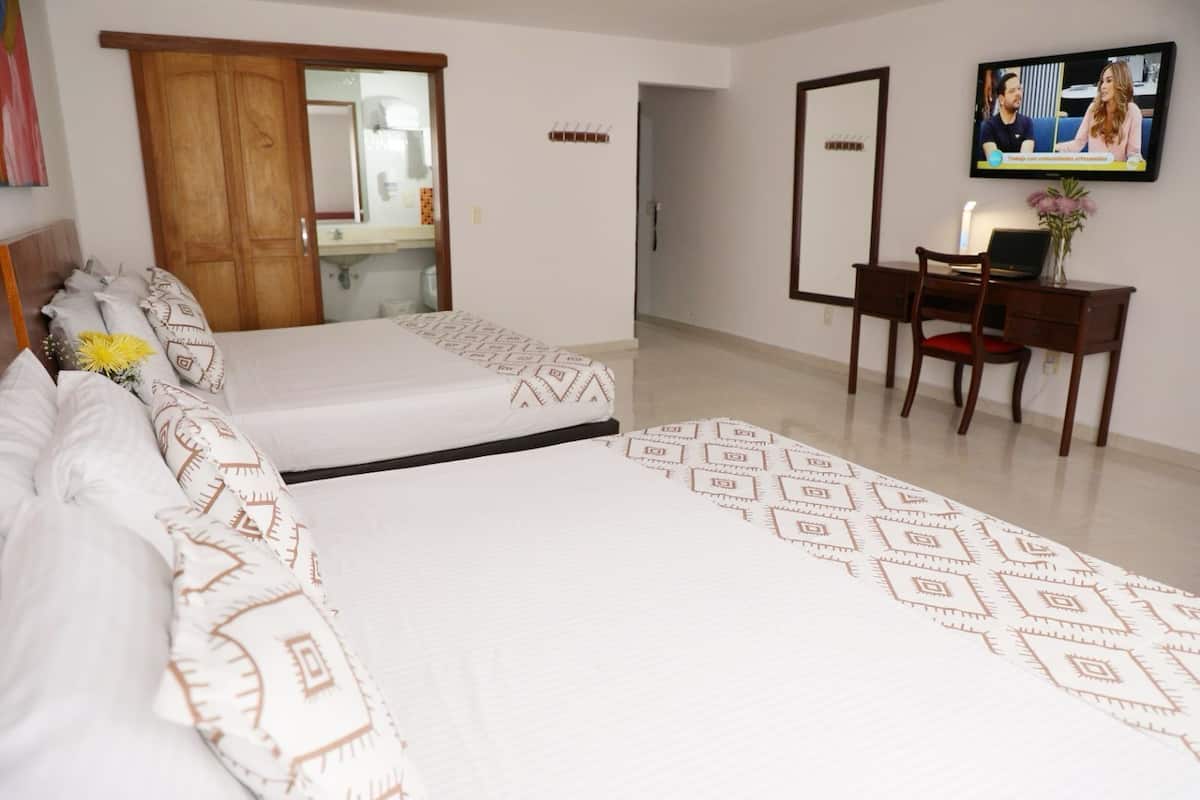 A hotel room with a bed, a desk, and a television.