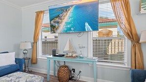Ein Zimmer mit einem Bett, einem Schreibtisch, einem Fernseher und einem Fenster mit Vorhängen.