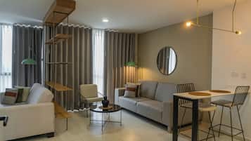 Una sala moderna con un sofá, sillas, una mesa de centro y una mesa de comedor.