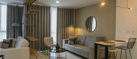 A modern living room with a sofa, chairs, a coffee table, and a dining table.