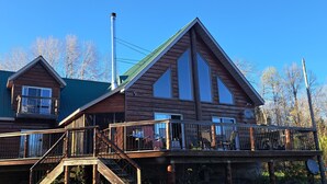 Eine zweistöckige Holzhütte mit Balkon und einem begrünten Dach.