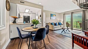 A modern apartment with a kitchen, dining area, and living room. - Mountain Views | Indoor Pool & Hot Tub Access (Gatlinburg)