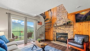 A spacious living room with a fireplace, a balcony with a scenic view, and a cozy seating area. - Mountain Views | Indoor Pool & Hot Tub Access (Gatlinburg)