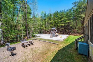 A backyard with a play area, picnic table, and a small building. - Sleeps 6 Indoor Pool Playground Hot Tub (Gatlinburg)