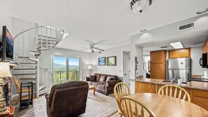 A spacious living area with a fireplace, a dining table, and a kitchen with modern appliances.