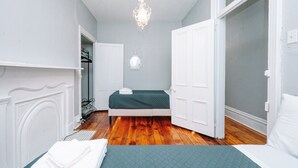 A bedroom with a bed, a mirror, and a chandelier.