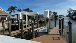 A dock with wooden pilings, a covered seating area, and a clear view of the water.
