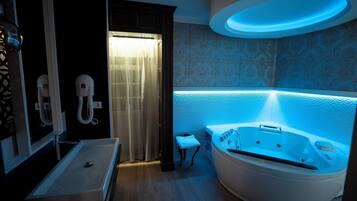A modern bathroom with a freestanding bathtub, a vanity with a mirror, and a shower area.