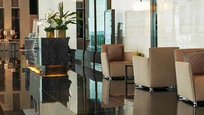 A modern lobby with reflective flooring, seating areas, and large pendant lights. - 1 Bedroom with Balcony Condo Apartment in Makati City (Makati)