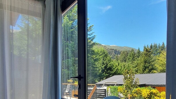 A room with a large sliding glass door leading to an outdoor deck. - Hygge Haus (Villa La Angostura)