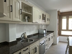 Fridge, microwave, coffee/tea maker, cookware/dishes/utensils