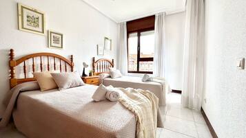 2 dormitorios, tabla de planchar con plancha, ropa de cama