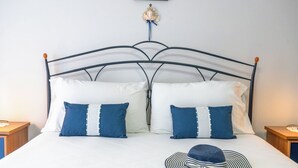 A bed with a metal frame, white bedding, and two blue pillows. - Terrazza sul Mare - Appartamento (Mascali)