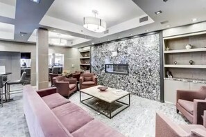 Ein modernes Interieur mit einer Marmorwand, Ledersofas, einem Couchtisch und integrierten Regalen.
