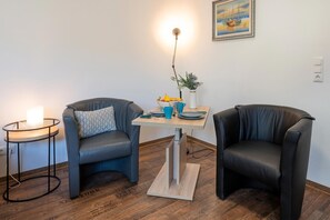 A room with two leather chairs, a small table with a vase and a bowl, and a lamp. - Traumhafte Strandnah-wohnung in Koserow für Zwei - Kimpi (Koserow)