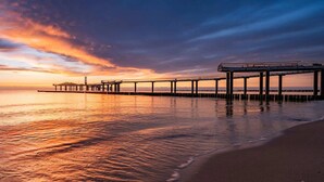 A pier extending into calm waters with a sunset in the background. - Ferienwohnung 02 - Kimpi (Koserow)