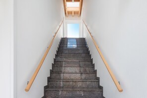 Una escalera con barandillas de madera y un tragaluz en la parte superior.