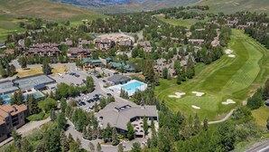 A resort with multiple buildings, a swimming pool, and a golf course. - Modern Golf View Condo + Resort Amenities (Sun Valley)