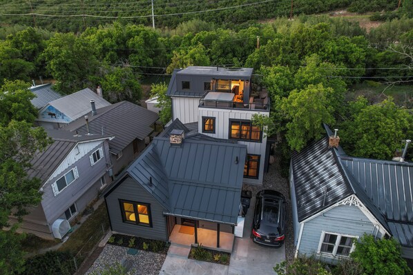 Ein modernes, zweistöckiges Haus mit Garage, großen Fenstern und einer überdachten Terrasse.