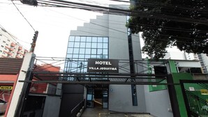 L’entrée d’un hôtel, avec une enseigne indiquant « HÔTEL VILLA JEQUITIBA ».