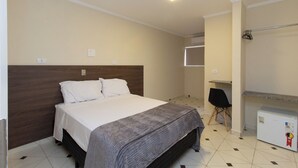 Une chambre à coucher avec un lit, un bureau et une armoire.