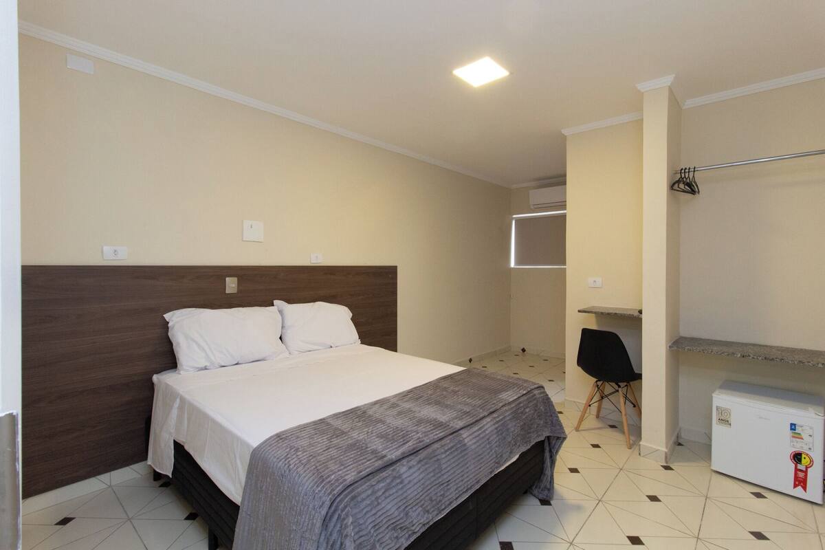 Ein Schlafzimmer mit Bett, Schreibtisch und Kleiderschrank.