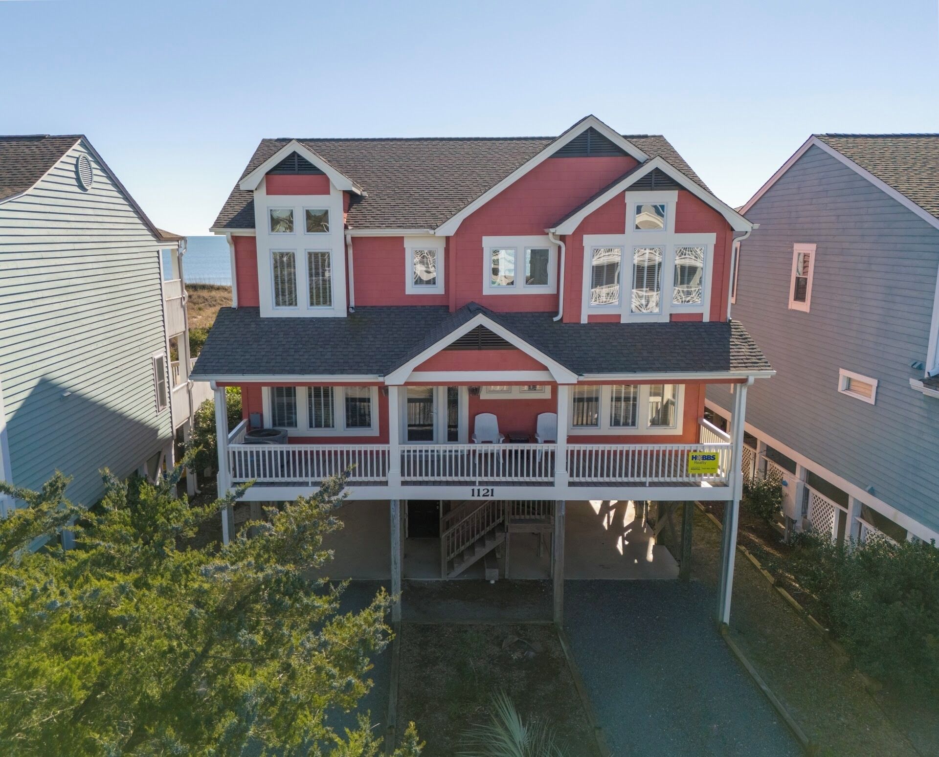 A two-story house with a front porch, a visible address number, and a small front yard.