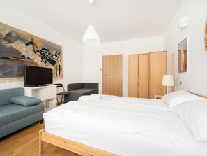 Relax in a spacious room with a large bed, flat-screen TV, and comfortable sofa.