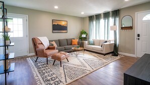 Un salon comprenant un canapé, un fauteuil, une table basse et un tapis.