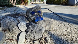 A beachfront property with a large house, a parked bus, and a rocky foreground. - Seabreeze Escape WF RV Lot 489 (Cudjoe Key)