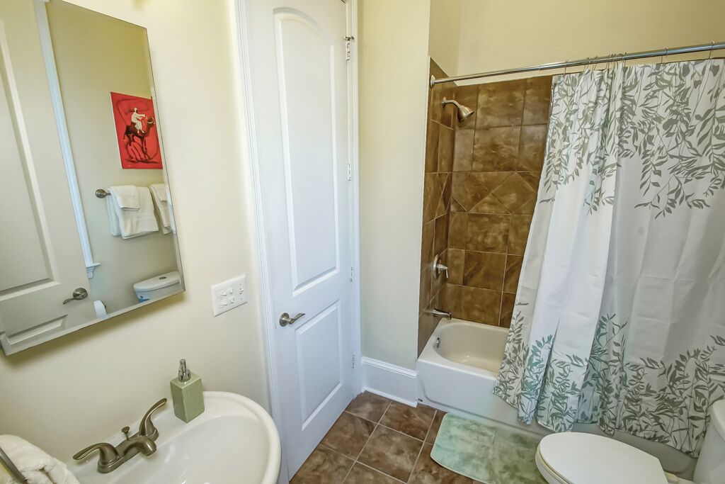 A bathroom with a bathtub, a toilet, and a sink.