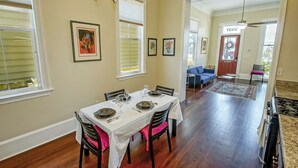 A dining area with a table set for four, a chandelier, and framed artwork on the walls. - Historic Victorian in New Orleans, minutes from tourist attractions (New Orleans)